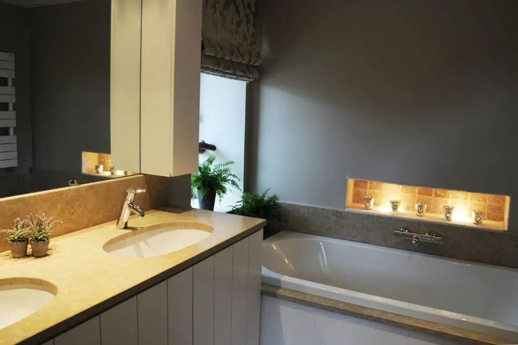 Renovated bathroom in Aix-en-Provence, double vanity with a stone top, bath and lit niche