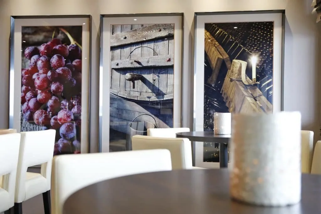 Large framed prints of a bunch of grapes, a barrel and a wine cellar
