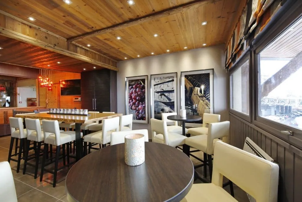Wine bar in Les Menuires: wooden ceiling, high tables and ivory bar stools