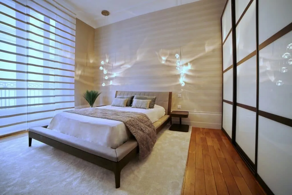 Bedroom with glass pendant lights, upholstered headboard and sliding wardrobe doors, Grenoble apartment