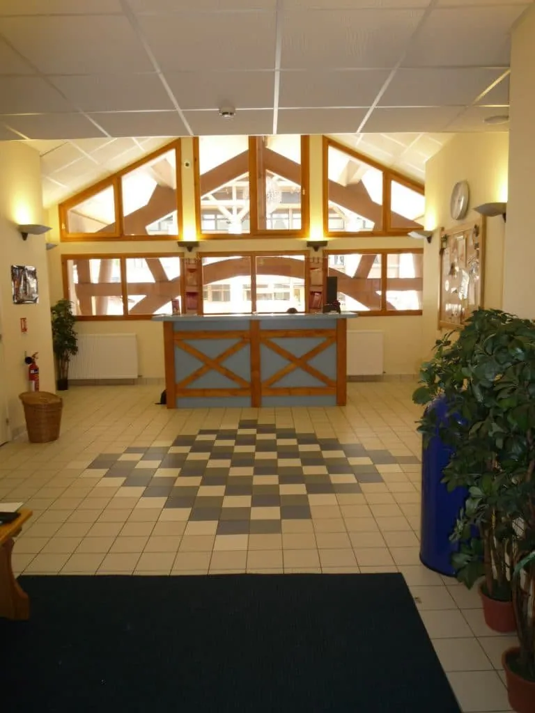 Reception hall before the redesign, blue and wood counter, grey checkerboard floor tiles