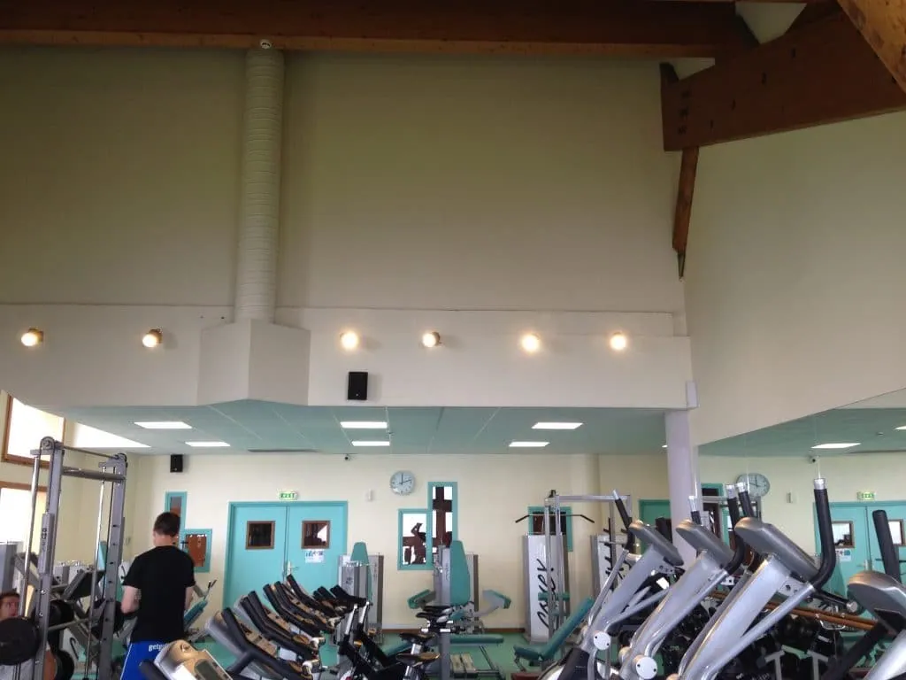 Before the project, gym with cream walls and turquoise doors, no wall decoration