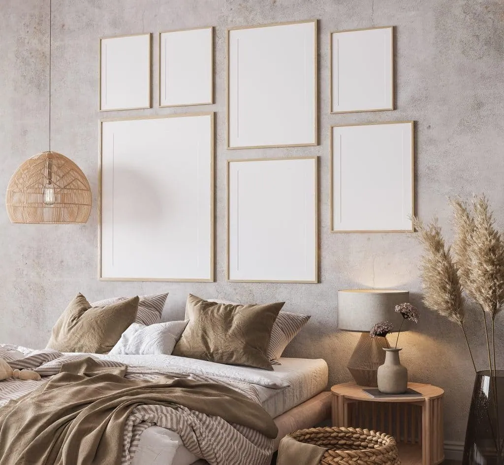 Bedroom in beige tones, blank light wood frames on a concrete-effect wall, rattan pendant light