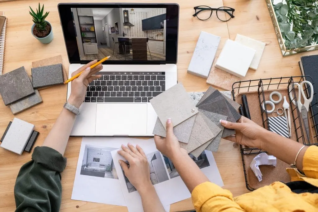 Interior design consultation, material samples and a 3D kitchen render on a laptop