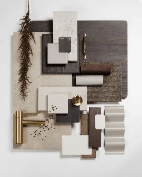 Planche de matériaux en bois foncé, pierre beige et laiton brossé, avec robinet et plante séchée