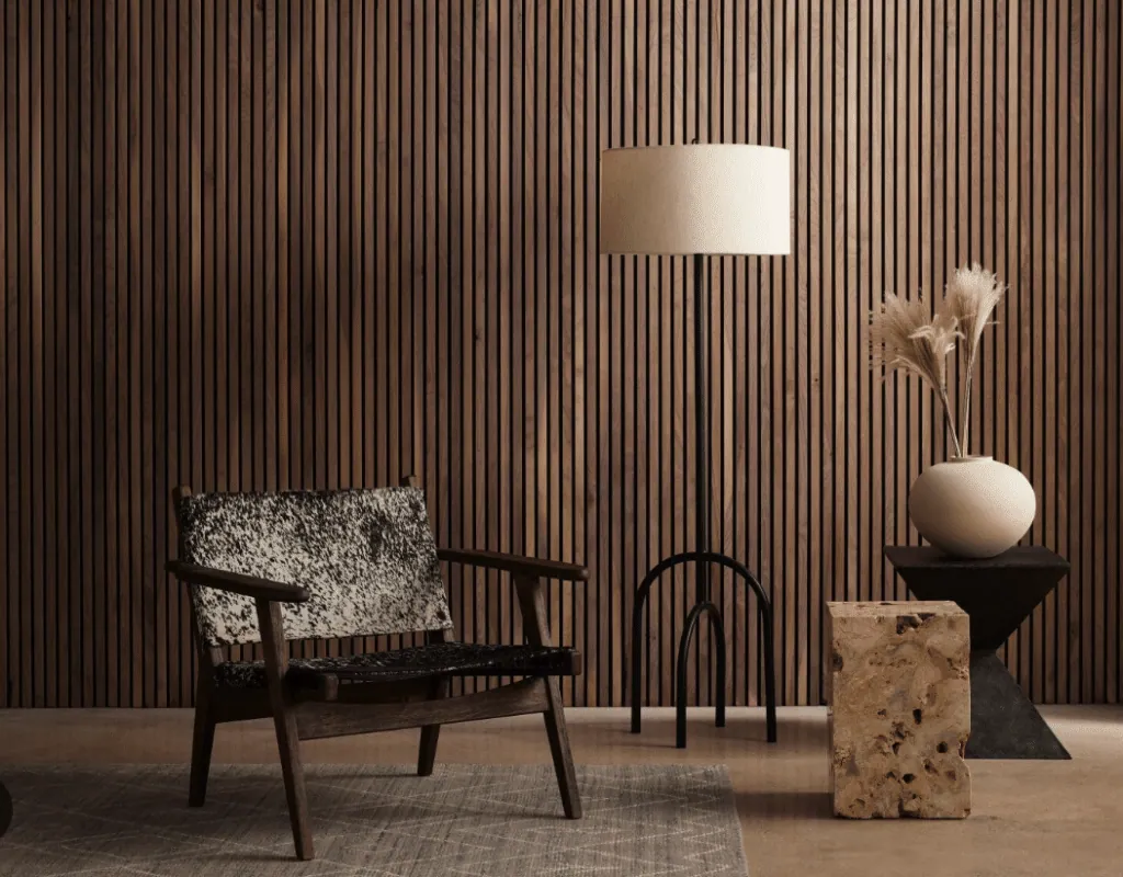 Fauteuil en peau de vache, lampadaire et cube en pierre devant des tasseaux de bois