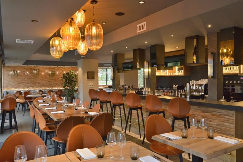 Le 205 brasserie in Dolomieu: tan leather chairs, amber glass pendant lights and bar