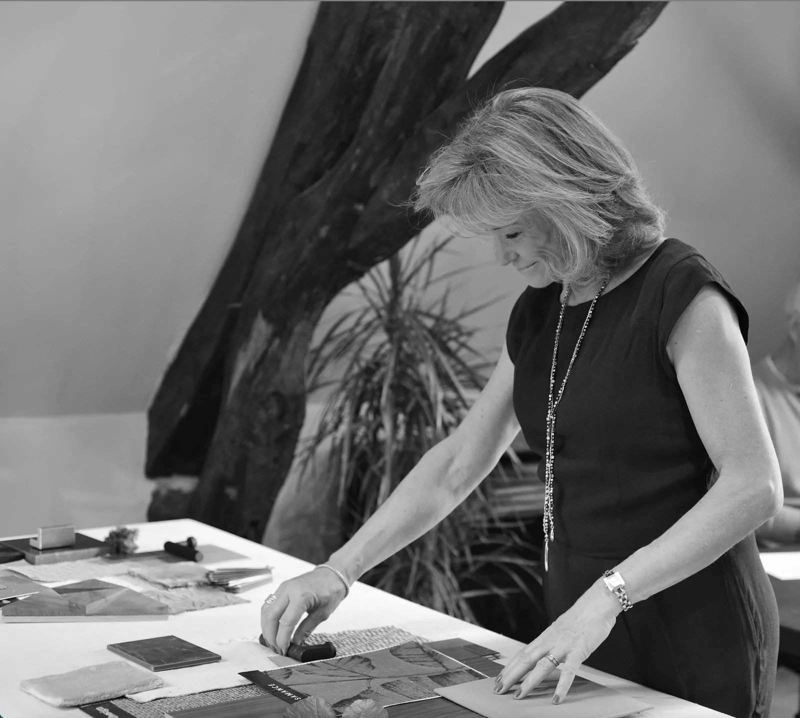 Lisa Paunovitch arranging fabric and material samples beneath an exposed timber beam