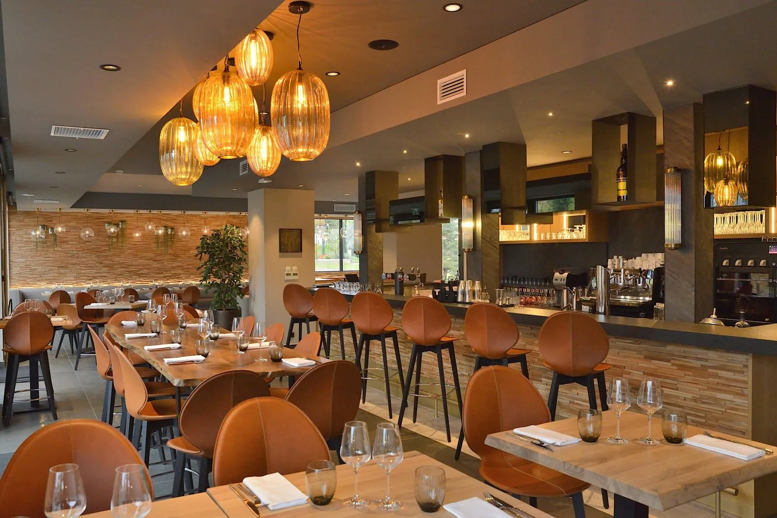 Dining room and bar at Le 205, with amber glass pendants and leather bar stools