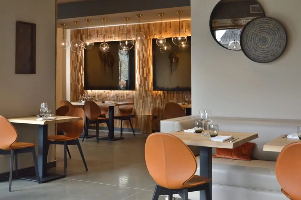 Round mirror and decorative tray above a banquette at Le 205