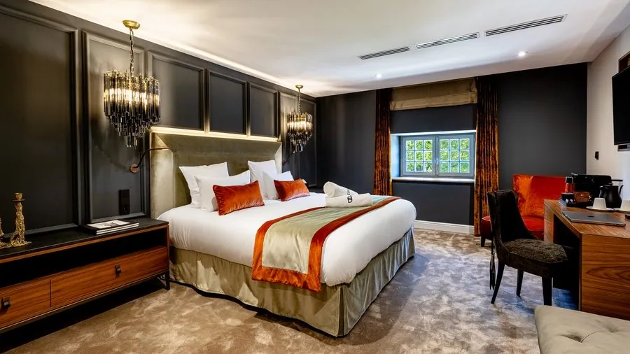 Chambre aux murs anthracite et linge de lit orangé