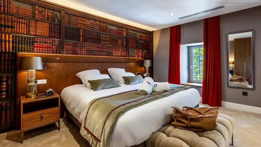 Chambre bibliothèque, rideaux rouges et tête de lit en cuir