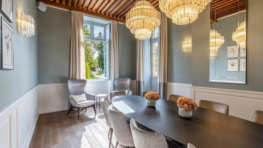 Salle à manger aux murs vert-de-gris et lustres en cristal