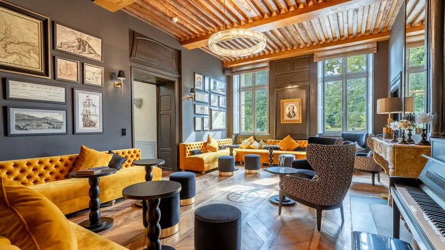 Grand salon aux canapés moutarde sous un plafond à la française