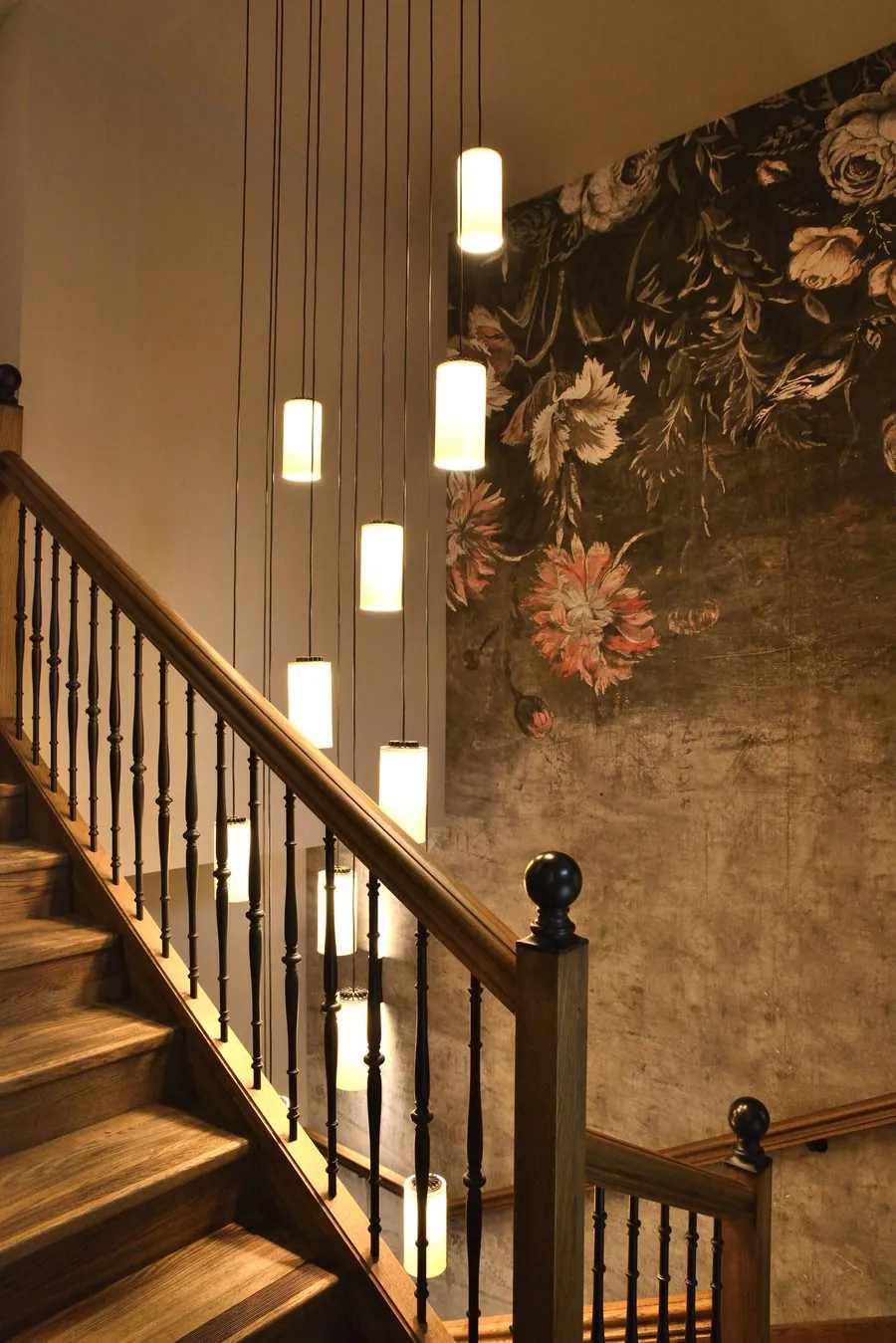 Escalier en bois, suspensions et papier peint fleuri