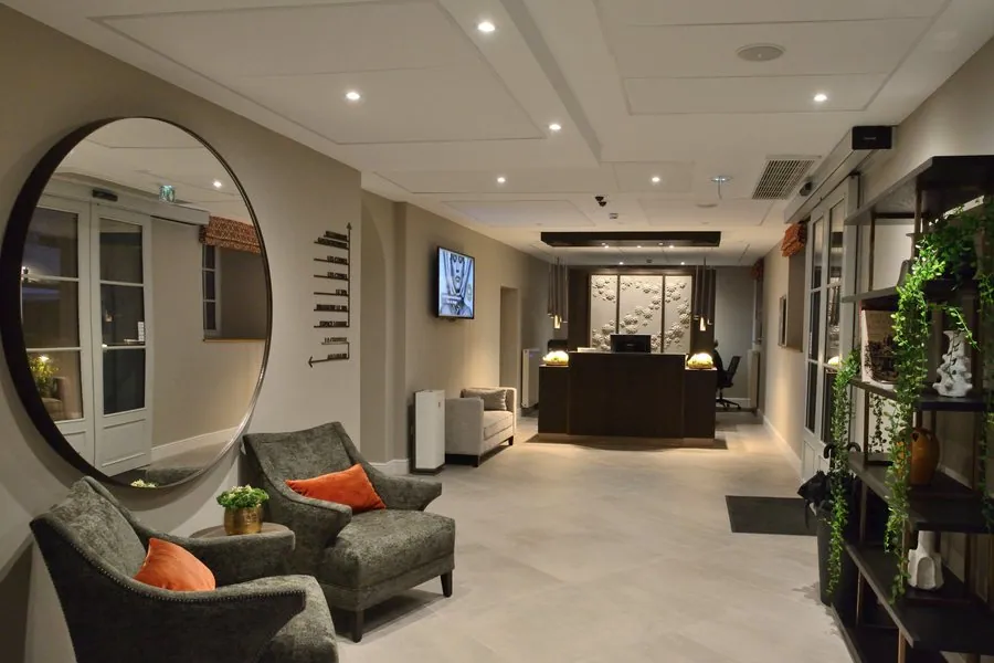 Hall de réception, miroir rond et fauteuils